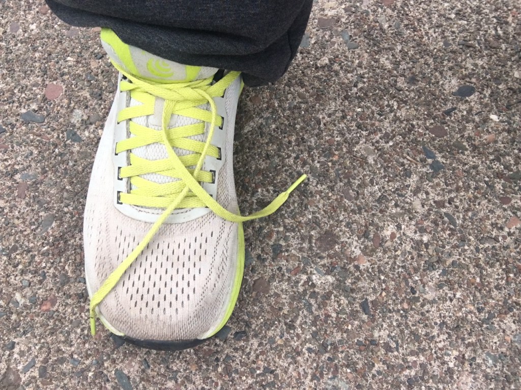 Running sneaker with an untied shoelace.